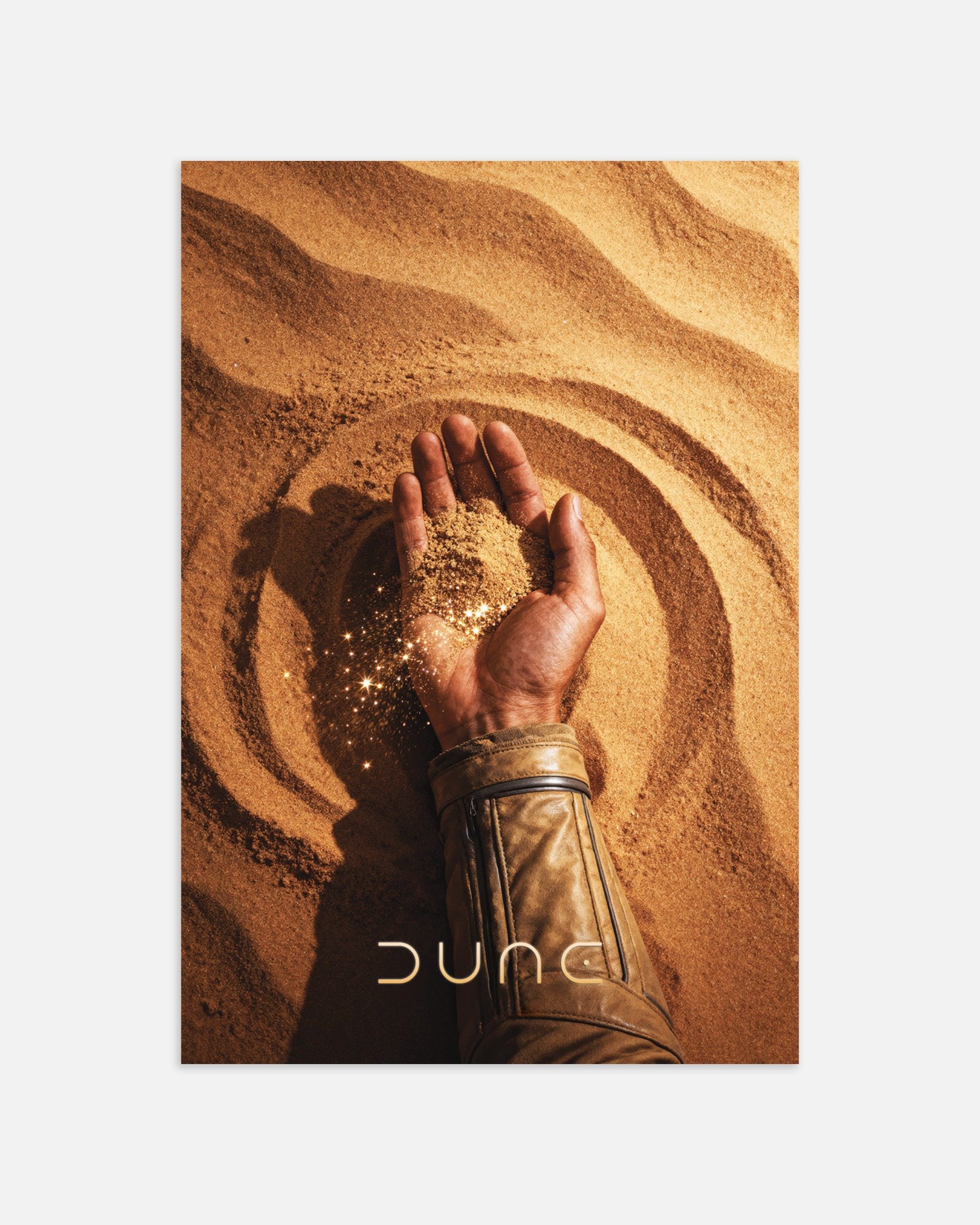Hand holding sand with 'Dune' logo on a sand background